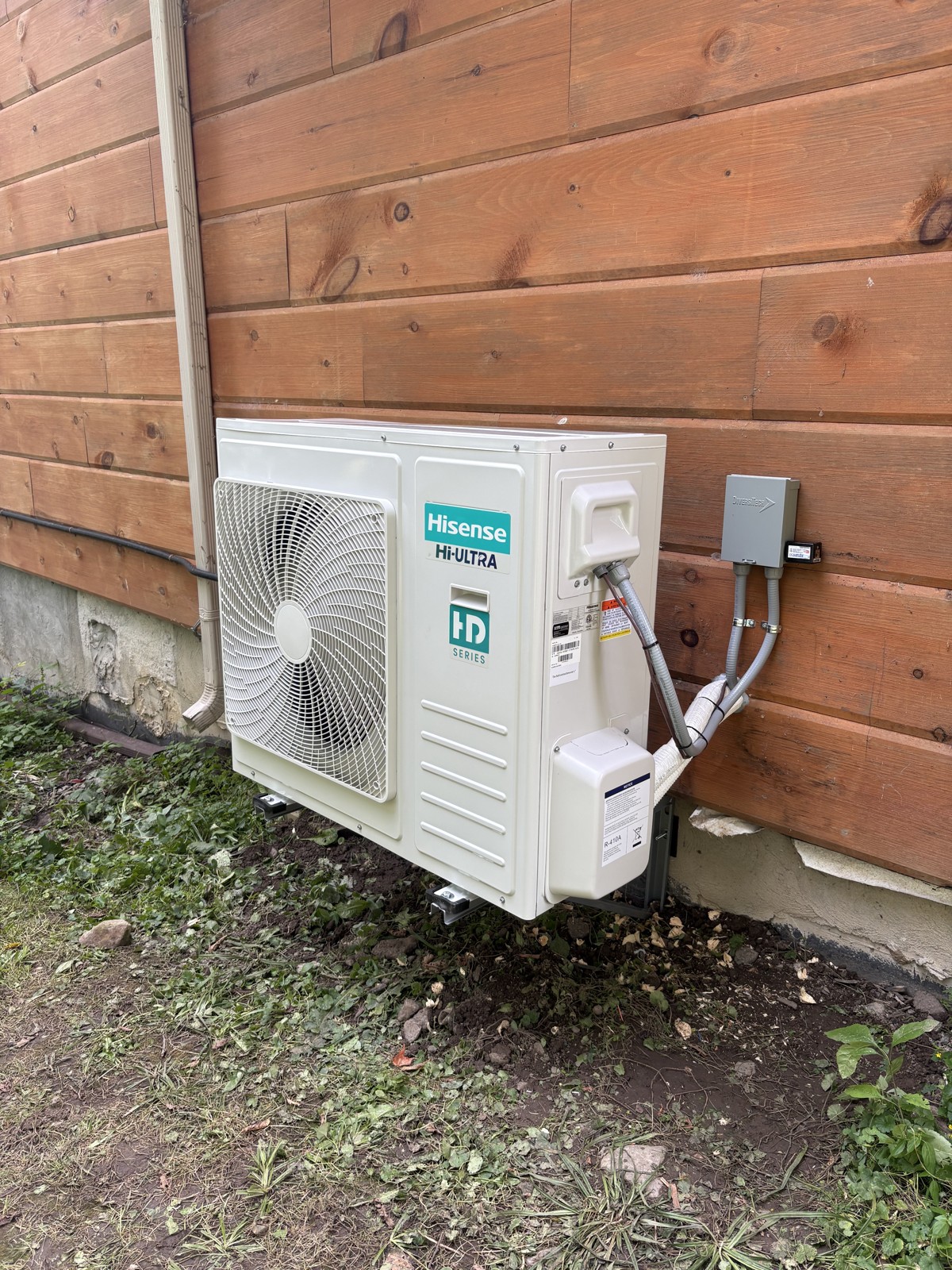 Hisense Hi-Ultra outdoor heat pump installed beside wood siding