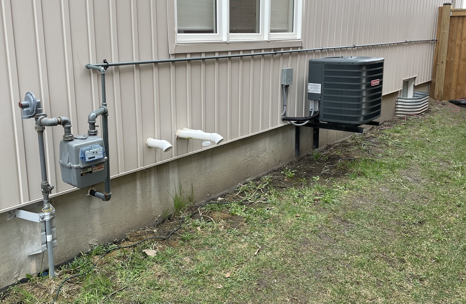 Gas meter and exterior piping along house siding